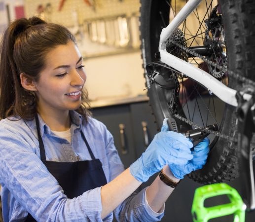 Mécanicienne réparant un vélo dans l’atelier Fontainebleau Bike Shop